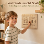 Kind nutzt einen Countdown-Kalender aus Holz, um die Tage bis zum Geburtstag sichtbar zu zählen